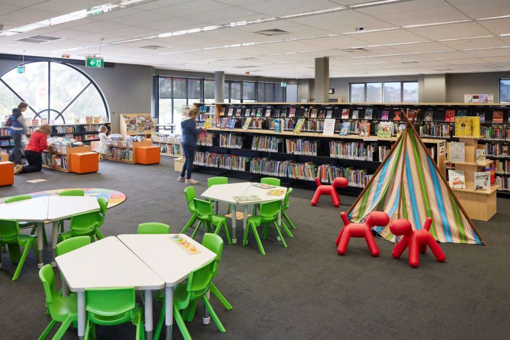 Kids tables and chairs and a playtent in the kids zone.